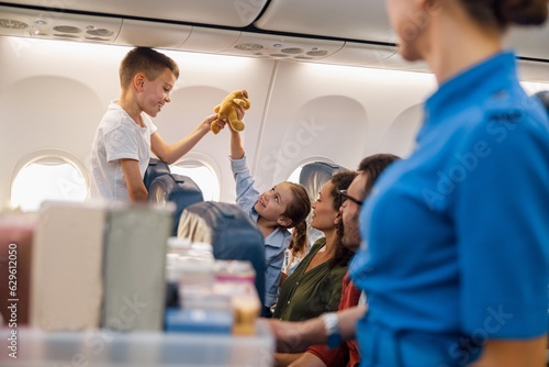 Two happy kids playing with a toy during flight. Family traveling together by plane. Vacation  travel  airline  service concept