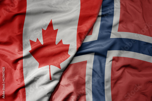 big waving realistic national colorful flag of canada and national flag of norway .