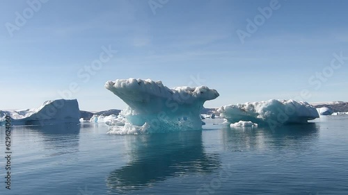 Small boat sailing through a fjord covered with drift ice and icebergs, Icefjord, Tasilaq, Denmark, Greenland, North America photo