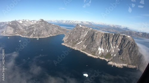 Helicopter flies over icebergs, fjords and rugged mountain landscapes, thin clouds, Nanortalik, Denmark, Greenland, North America photo