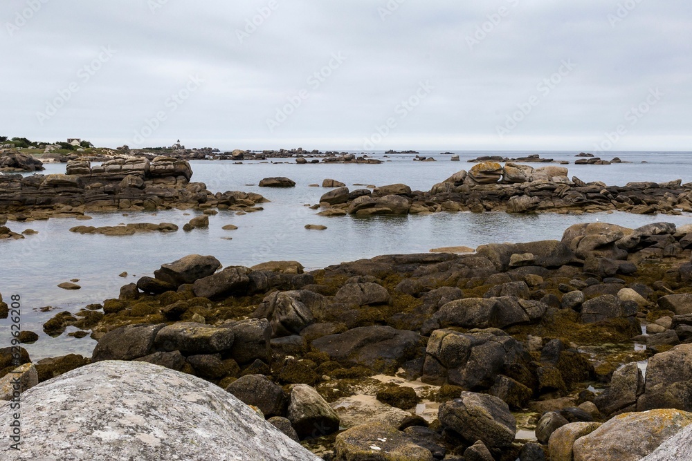 Landscape of a rocky shore surrounded by the water under a cloudy sky in the countrysid0e