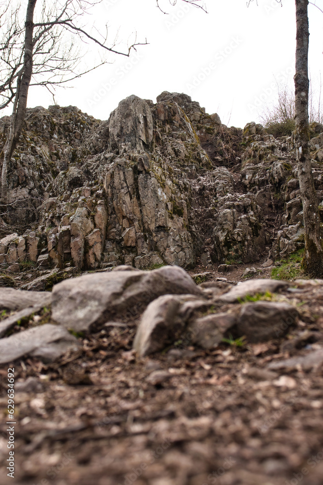 Rocks on a path in front of Koenigsstuhl formation at Thunder Mountain in Dannenfels in the Palatinate Forest of Germany on a cloudy spring day. Rocks on a path in front of Koenigsstuhl formation at Thunder Mountain in Dannenfels in the Palatinate Forest of Germany on a cloudy spring day.