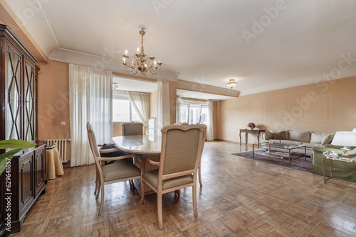 Spacious living room of a house with parquet floors in need of stabbing and a marble dining