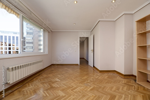 Large living room of a house with parquet floors without furniture, with plaster moldings © Toyakisfoto.photos