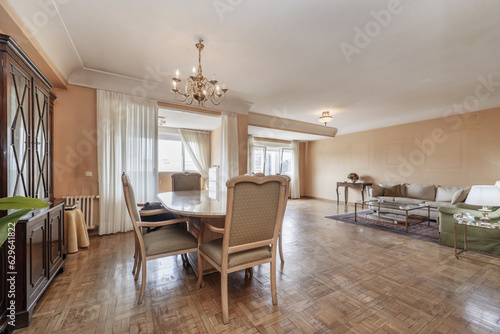 Fototapeta Naklejka Na Ścianę i Meble -  Spacious living room of a house with parquet floors in need of stabbing and a marble dining