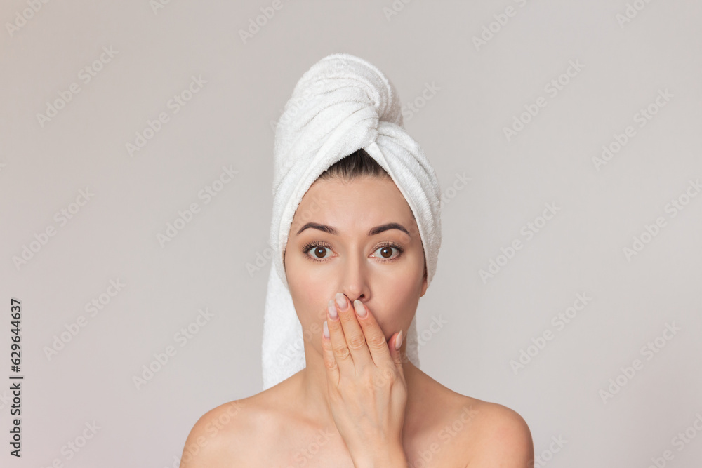 a close-up photo of a young naked dark-haired cute woman with a white towel wrapped around her head, who covers her mouth with her hand in surprise. a close-up photo of a young naked dark-haired cute woman with a white towel wrapped around her head, who covers her mouth with her hand in surprise.
