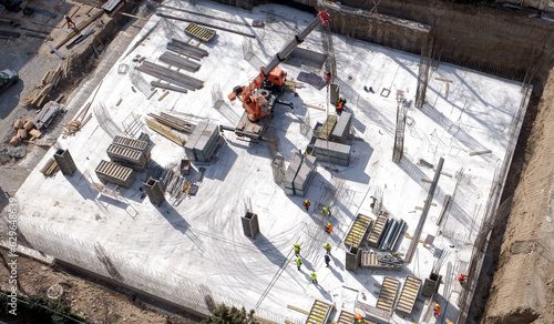 Aerial Top Down View on a Constructions Site with Team of Engineers and Worker
