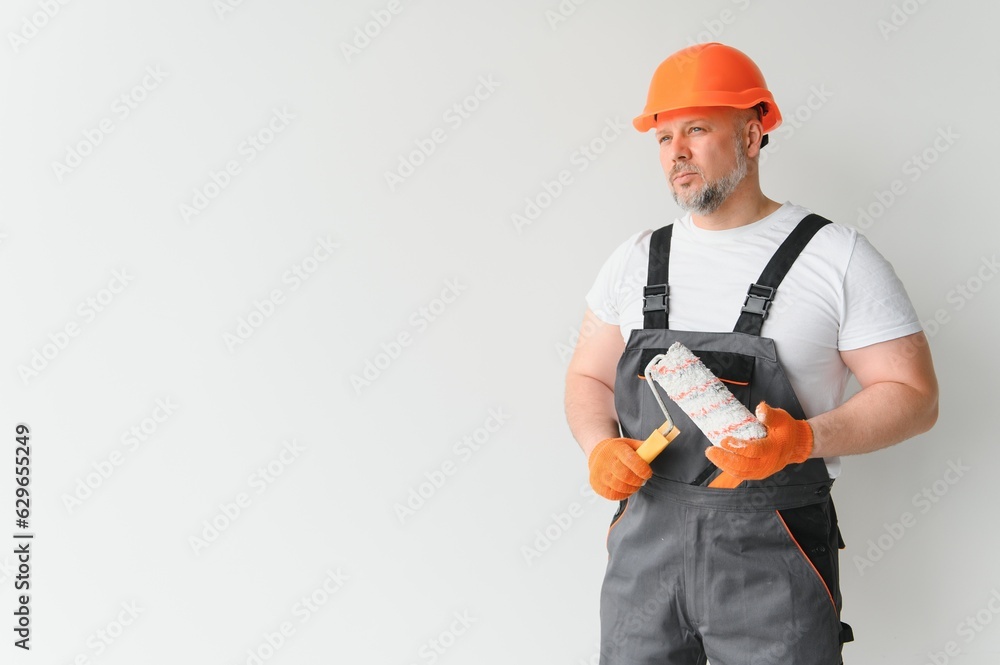 Painter using a paint roller and painting a wall isolated on white background.