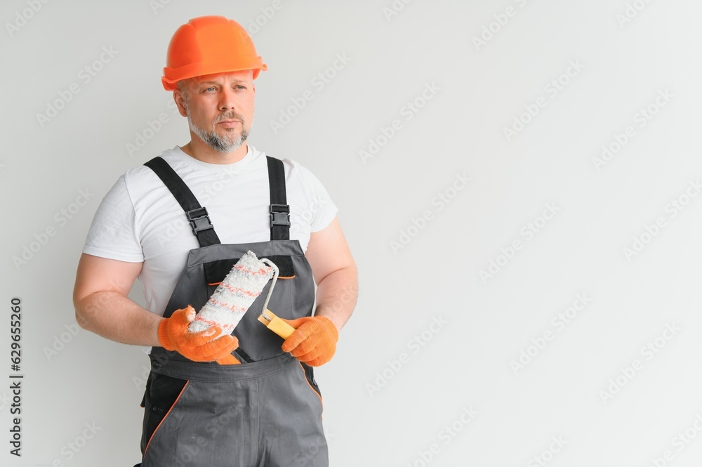 Painter man painting the wall in home, with paint roller and white color paint. Room renovations at house. Painter man painting the wall in home, with paint roller and white color paint. Room renovations at house.