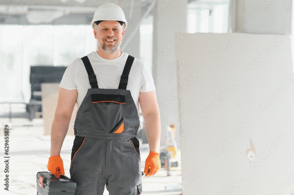 Portrait of a builder in the process of working on a construction site indoors Portrait of a builder in the process of working on a construction site indoors