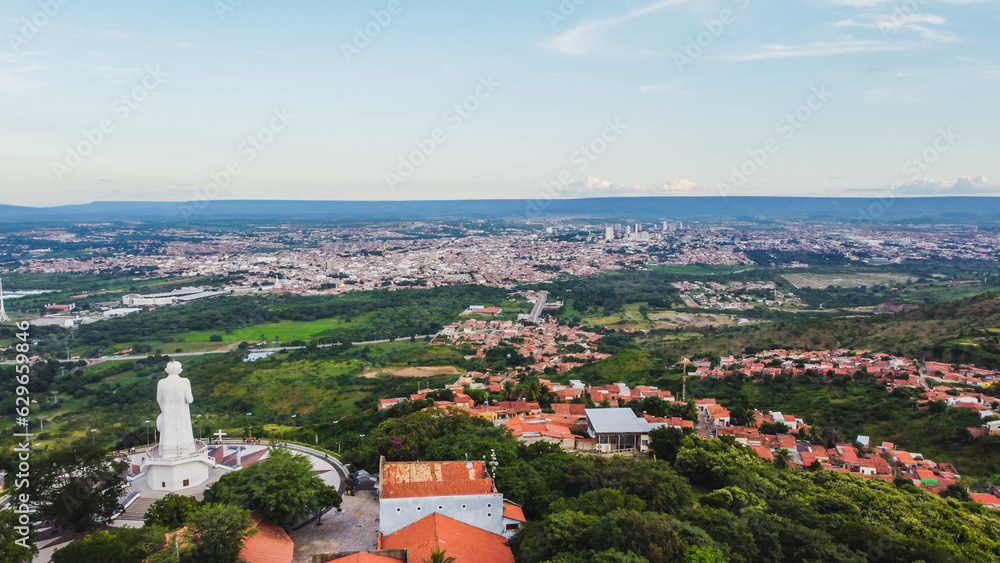 Visão aérea da cidade de Juazeiro do Norte no Ceará com visual da estátua de Padre Cícero visto do alto por um drone. 