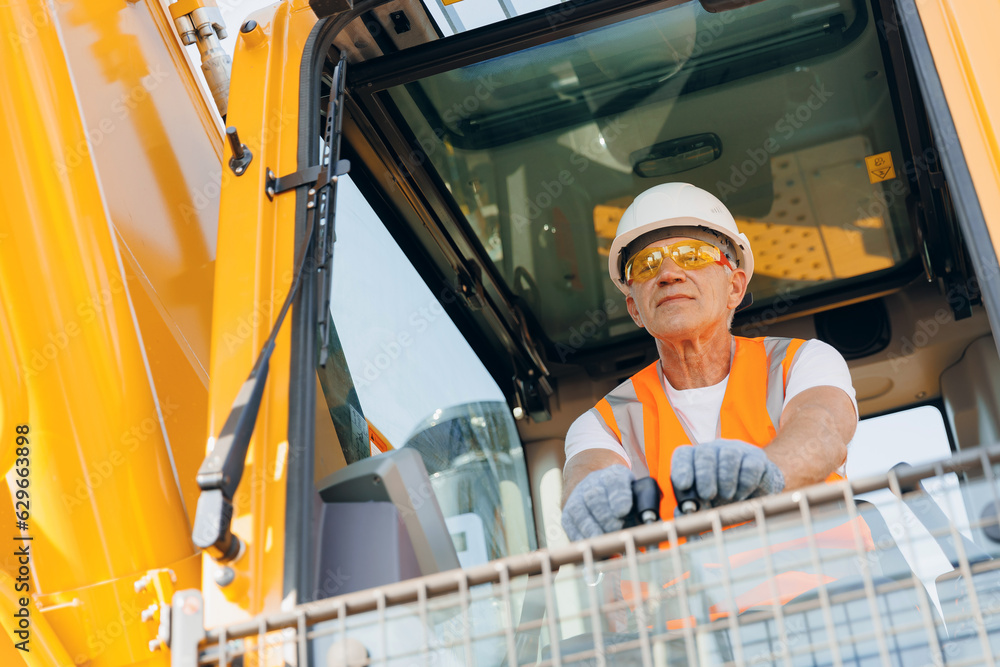 Man driver builder operate crane or excavator at construction site with sun light. Portrait Industry worker Man driver builder operate crane or excavator at construction site with sun light. Portrait Industry worker