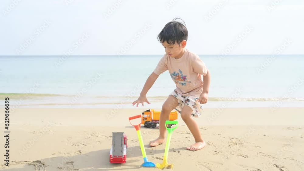 Asian boy with sunglasses and a hat playing on the beach. Asian boy with sunglasses and a hat playing on the beach.