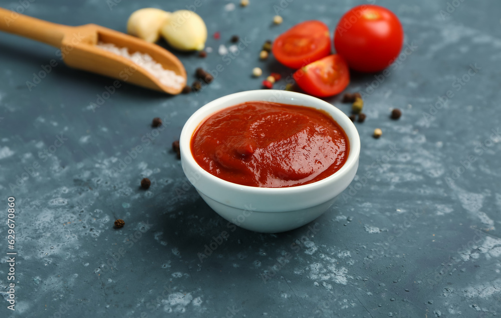 Bowl with tasty tomato paste, garlic and spices on grey grunge background Bowl with tasty tomato paste, garlic and spices on grey grunge background
