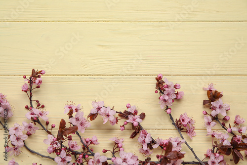Blooming branches on yellow wooden background