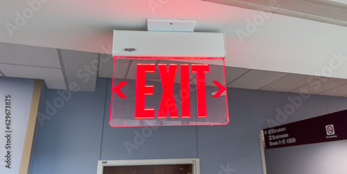 red exit sign above the door, a symbol of safety, escape, and a way out in emergencies. Represents hope and assurance in uncertain situations. Concept of finding an exit