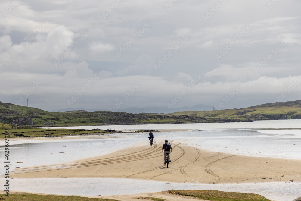 two unknown biker on the beach on the isle of Colonsay in Scotland