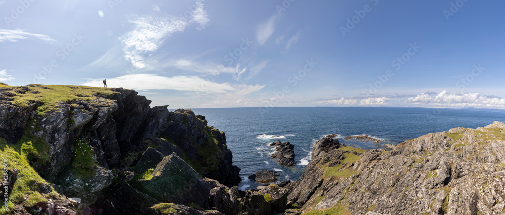 panoramic shot of woman on the cliffs of Balnahard on isle of Colonsay, Scotland