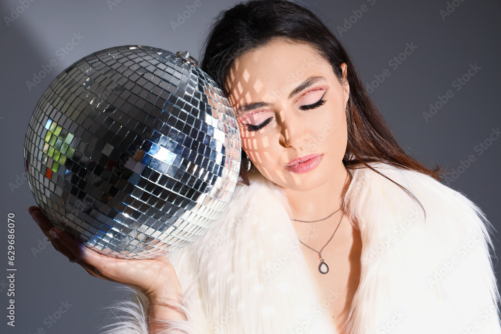 Naklejka premium Young woman with disco ball and white fur coat, party and celebration lifestyle, nightlife and entertainment