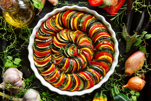 Vegan french tian in a casserole dish on the black background, top view. 
