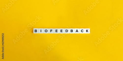 Biofeedback Word on Block Letter Tiles on Yellow Background. Minimal Aesthetic. photo