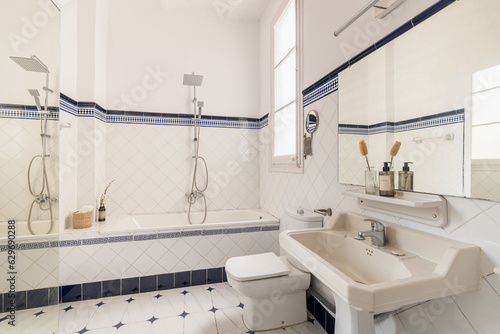 Modern interior design of a domestic bathroom with bathtub, shower, and sink