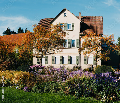 House with nice garden in fall. Flowers in the City Park of Bietigheim-Bissingen, Baden-Wuerttemberg, Germany, Europe. Autumn Park and house, nobody, bush and grenery photo