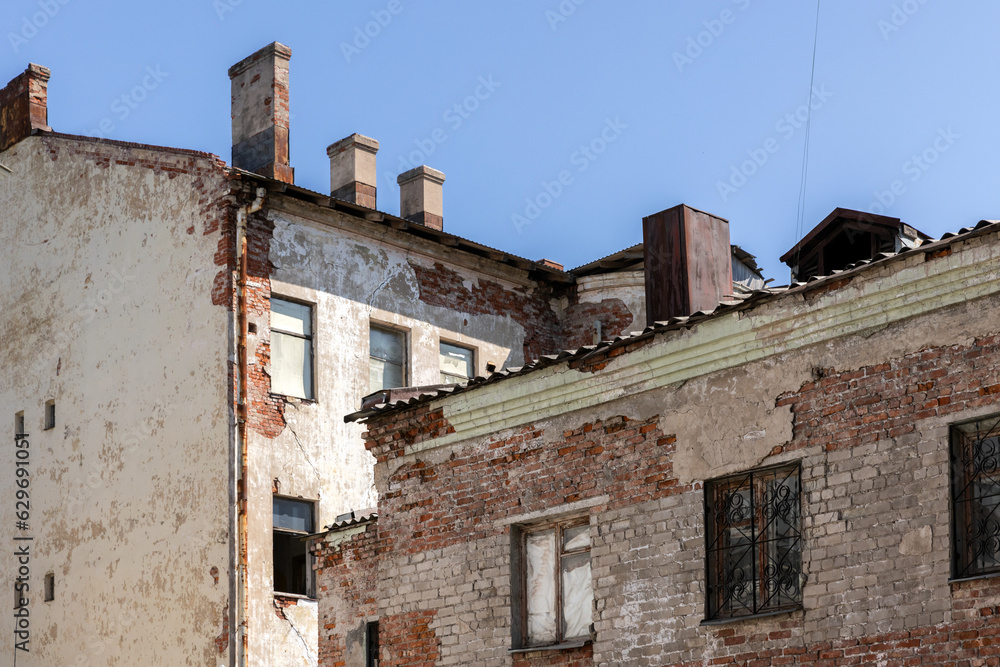 Old residential houses with shabby facades are under blue sky