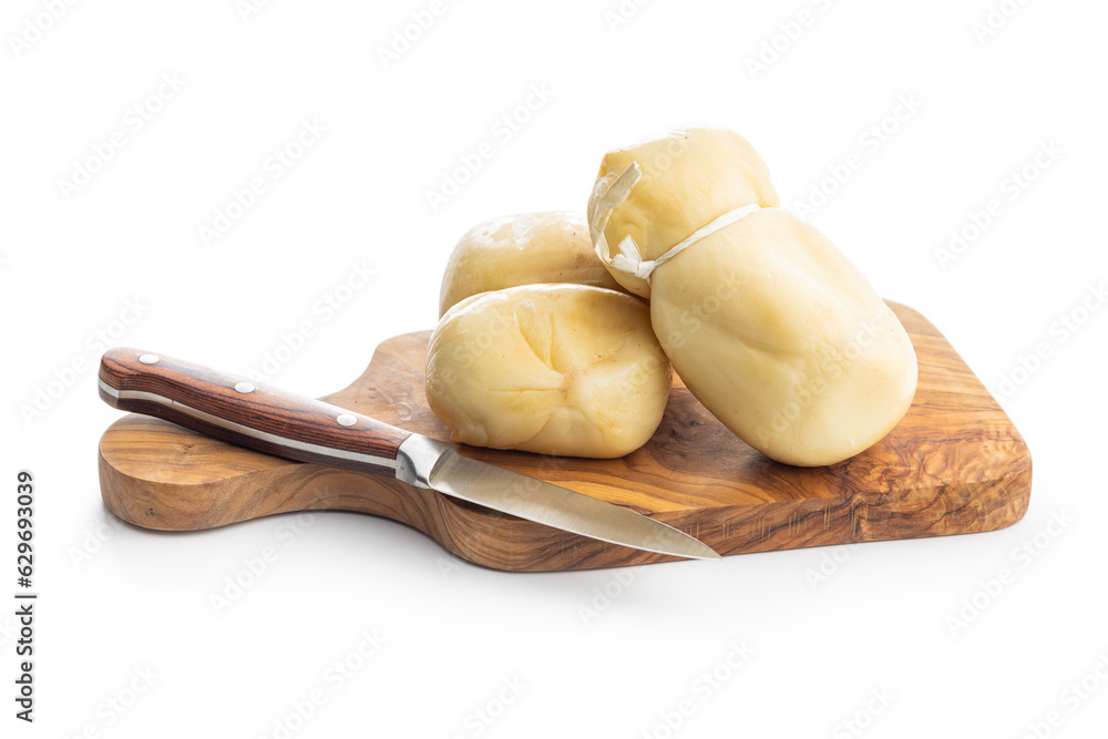 Smoked scamorza cheese on cutting board isolated on white background.