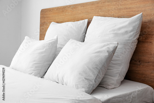 Fotografija Comfortable double bed and white pillows in interior of light bedroom