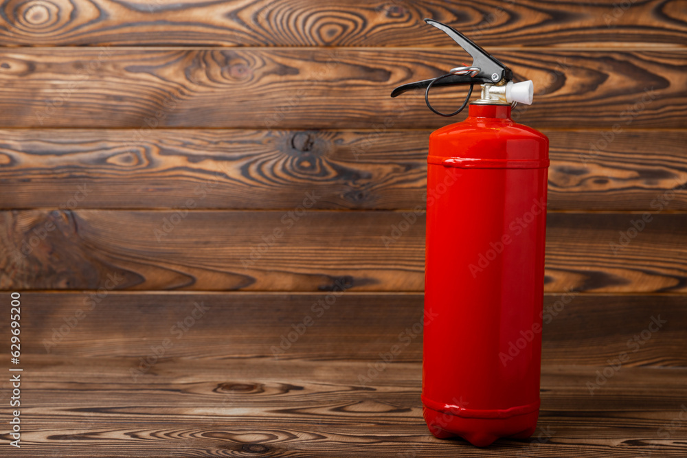 Fototapeta premium Fire extinguisher on brown texture background. Fire protection, home fire extinguisher. home security concept. Place for text. Copy space.banner