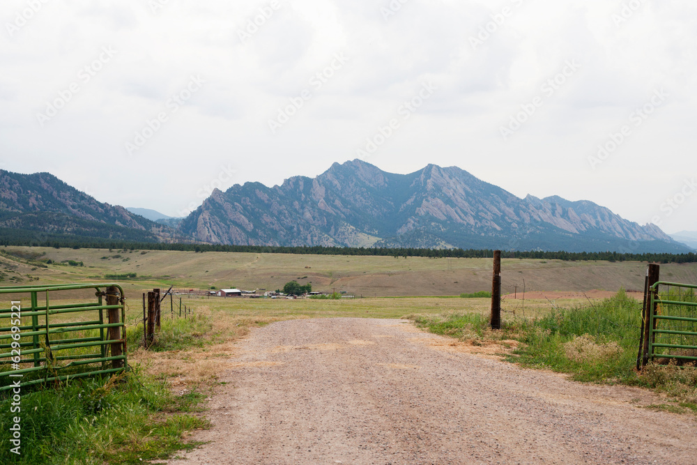 a gate and dirt road near mountains