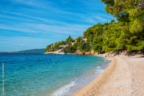 Fototapeta Naklejka Na Ścianę i Meble -  Gorgeous small pebble beach under lush pine treetops on sunny island of Hvar