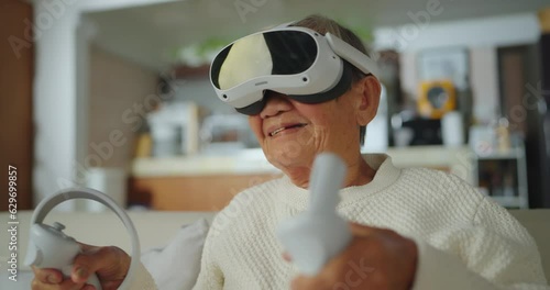 Senior asian woman relaxing and playing VR goggles and using futuristic tablet at home. the concept of metaverse, versual reality, future, technology, and internet of things. photo