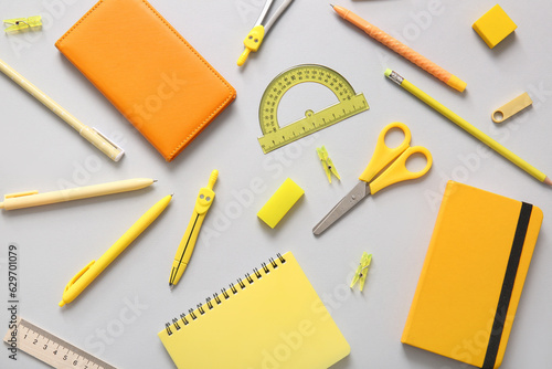 Different school stationery and notebooks on grey background