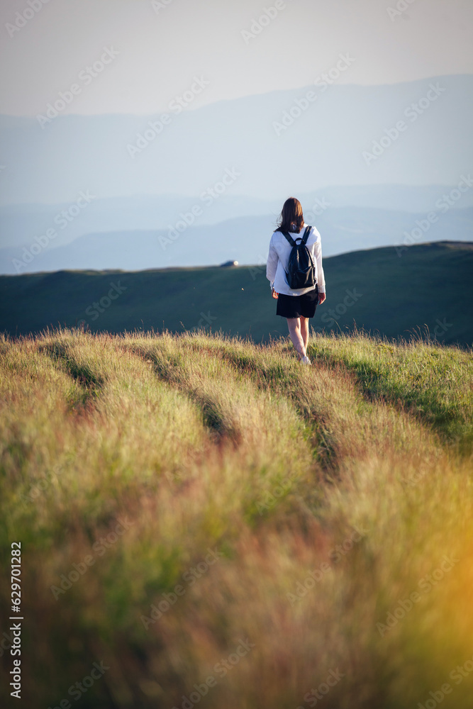 Young Girl with a Backpack Walks Alone in the Ukrainian Carpathian Mountains