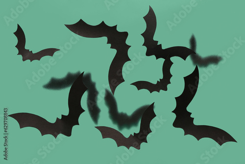 Paper bats for Halloween party on green background