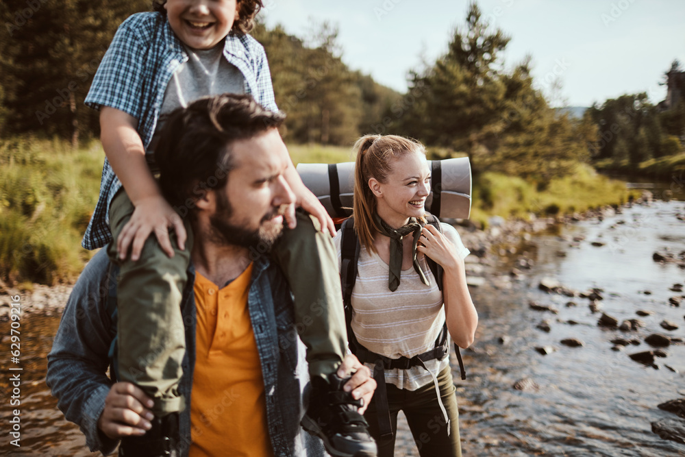 Young family hiking in the forest and crossing a creek together Young family hiking in the forest and crossing a creek together