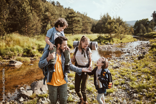 Young family hiking in the forest next to a creek