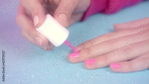 Painting pink nails with on blue glitter background - Barbie inspired photo