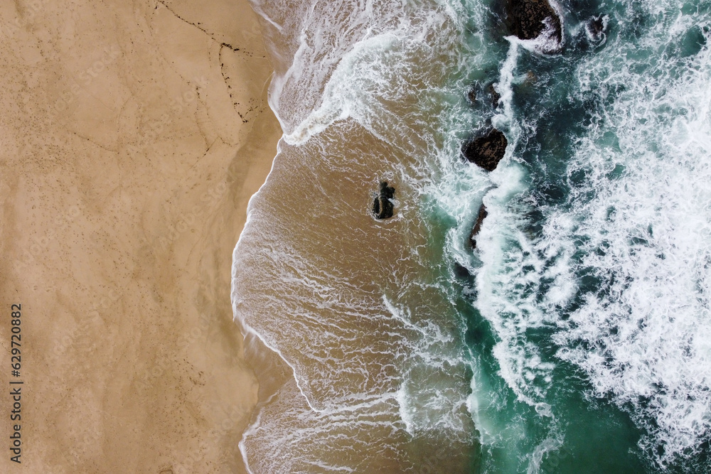 Aerial view over rocks and sea waves. Portugal, 2023.