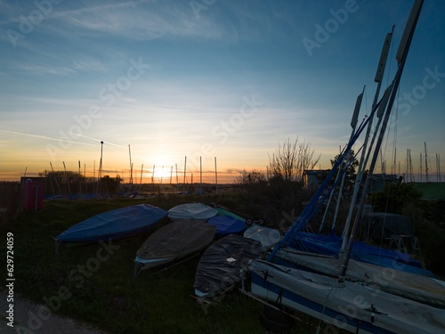 Sailing dinghies and boat masts at sunset photo