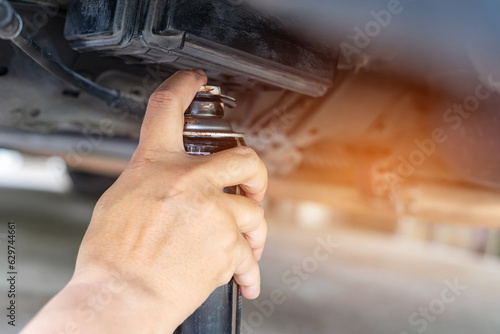 Basic vehicle inspection and maintenance, Close up hand a man holding anti-rust paint spraying car undercarriage to prevent rust, Car good protection and service concept by myself