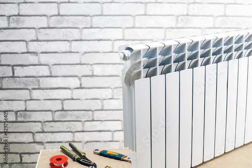 Heating radiator with tools against wall in the apartment. repair heating system concept. place for text.