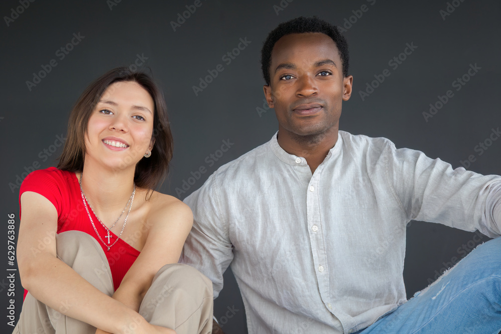 young couple boyfriend and girlfriend smiling together sitting in studio young couple boyfriend and girlfriend smiling together sitting in studio