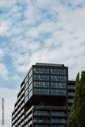 Modern glass office building exterior with glass facade on clear sky background. Transparent glass wall of office building. Element of facade of modern European building Commercial office buildings