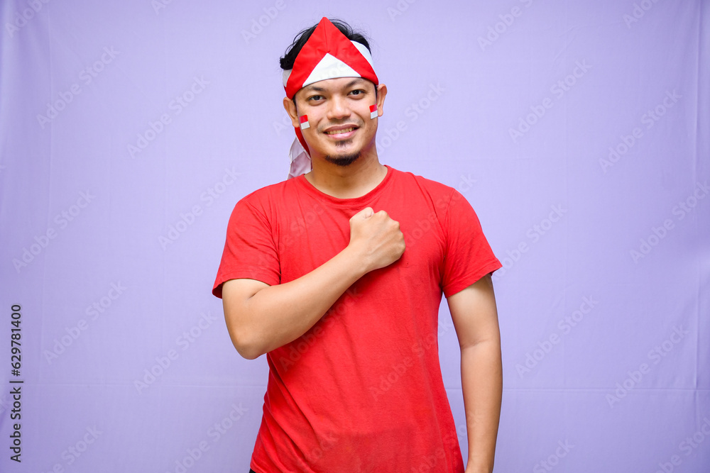 man giving respect. indonesia independence day on 17 August, wearing red shirt. isolated on purple background. copyspace 