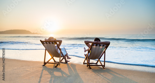 Fototapeta Naklejka Na Ścianę i Meble -  Young couple sunbathing on beach chair
