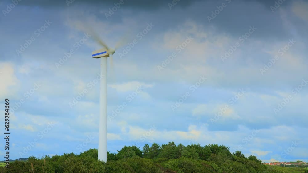 Windmill spinning and clouds racing by with cloud shadows on tree line. Time lapse 30x. Windmill spinning and clouds racing by with cloud shadows on tree line. Time lapse 30x.