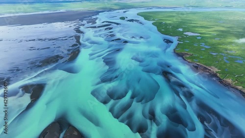 Aerial view tilting over colorful, blue formations on the Olfusa river in Iceland photo